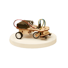 Small wooden DIY robot car with wheels on a white platform against a black background