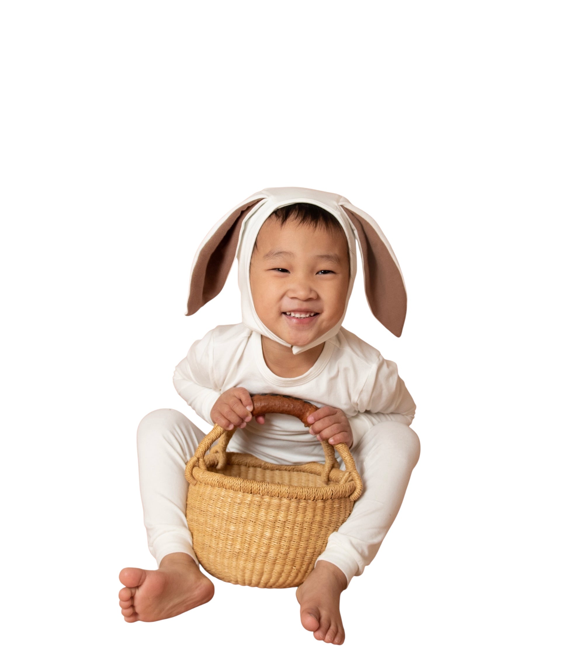 Child wearing a bunny costume with a basket on a white background