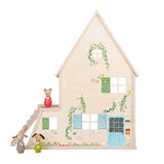 Small wooden house with decorative elements and toy figures on a white background